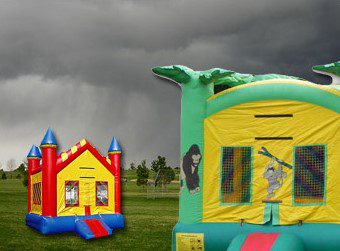 A couple of inflatable castles in the grass.