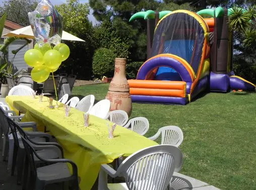 A table and chairs in the middle of an outdoor party.