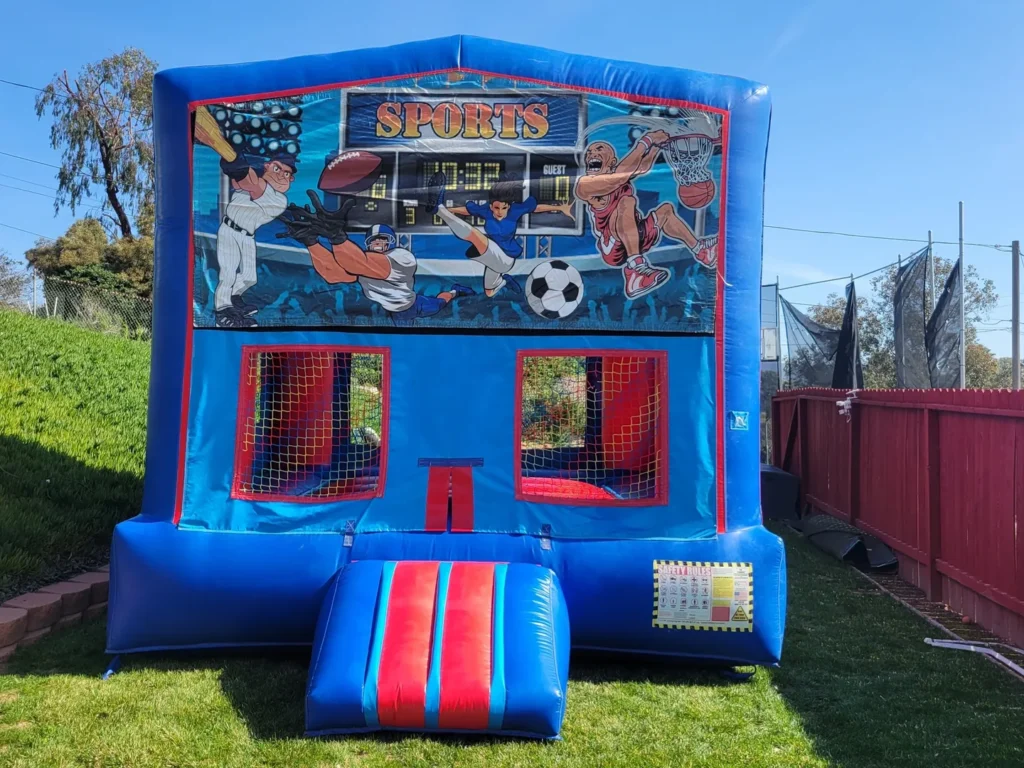 A blue and red inflatable bounce house with soccer players on it.