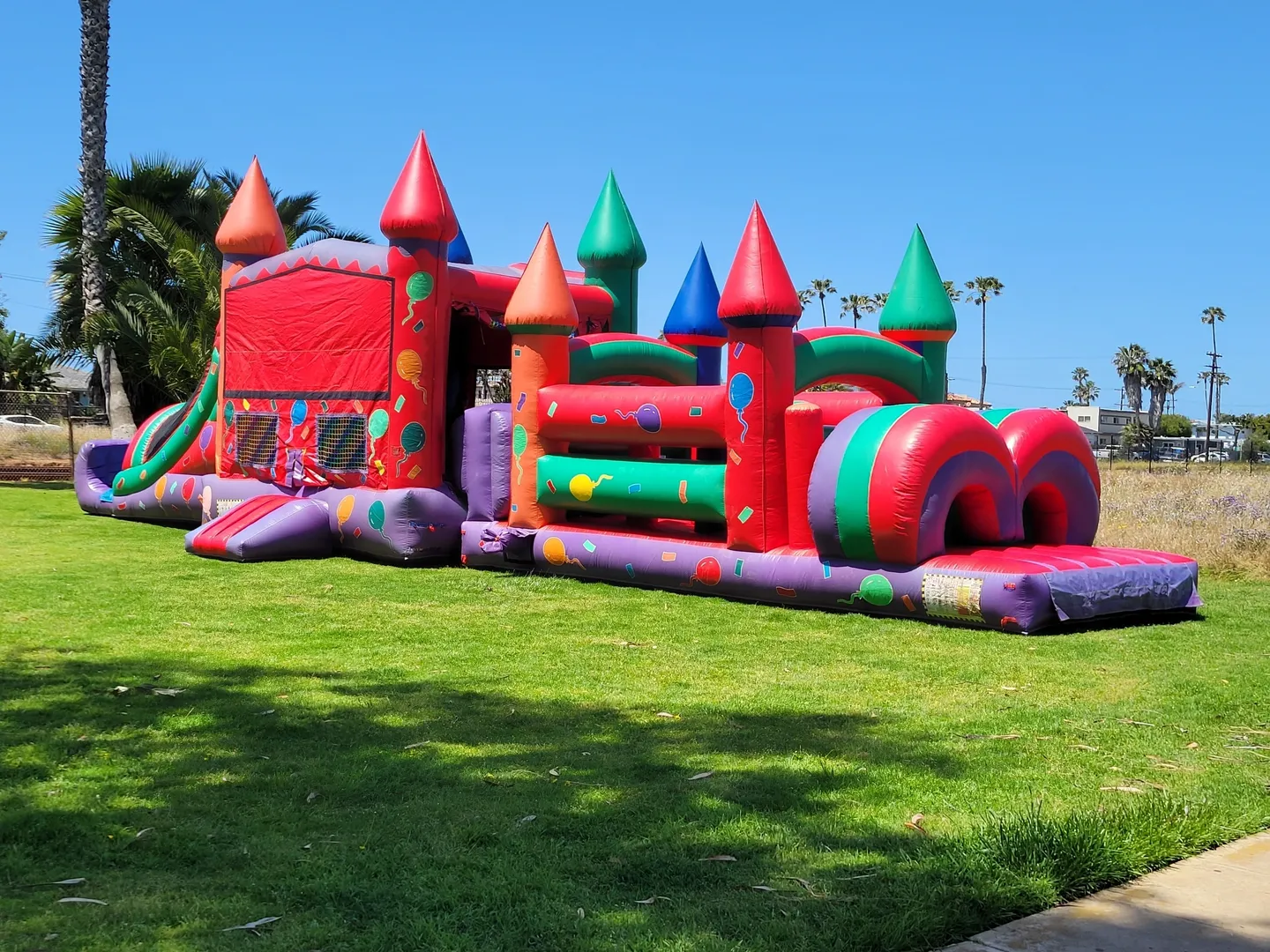 A large inflatable obstacle course in the middle of a park.