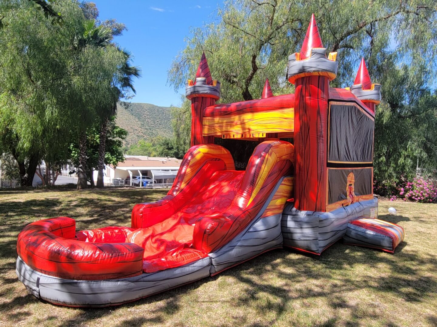 A red and silver inflatable castle with slide.