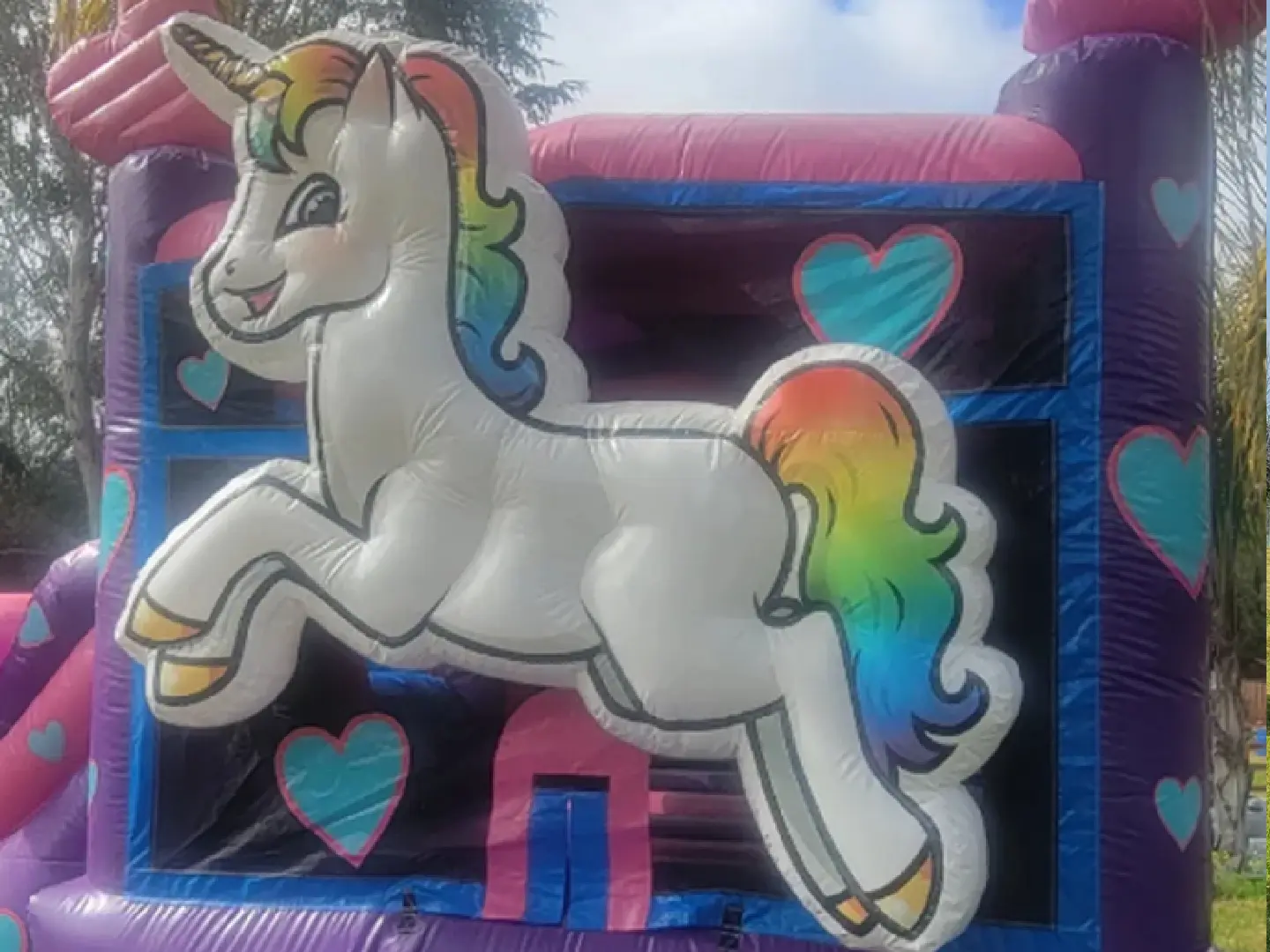 A unicorn jumping in the air on an inflatable.