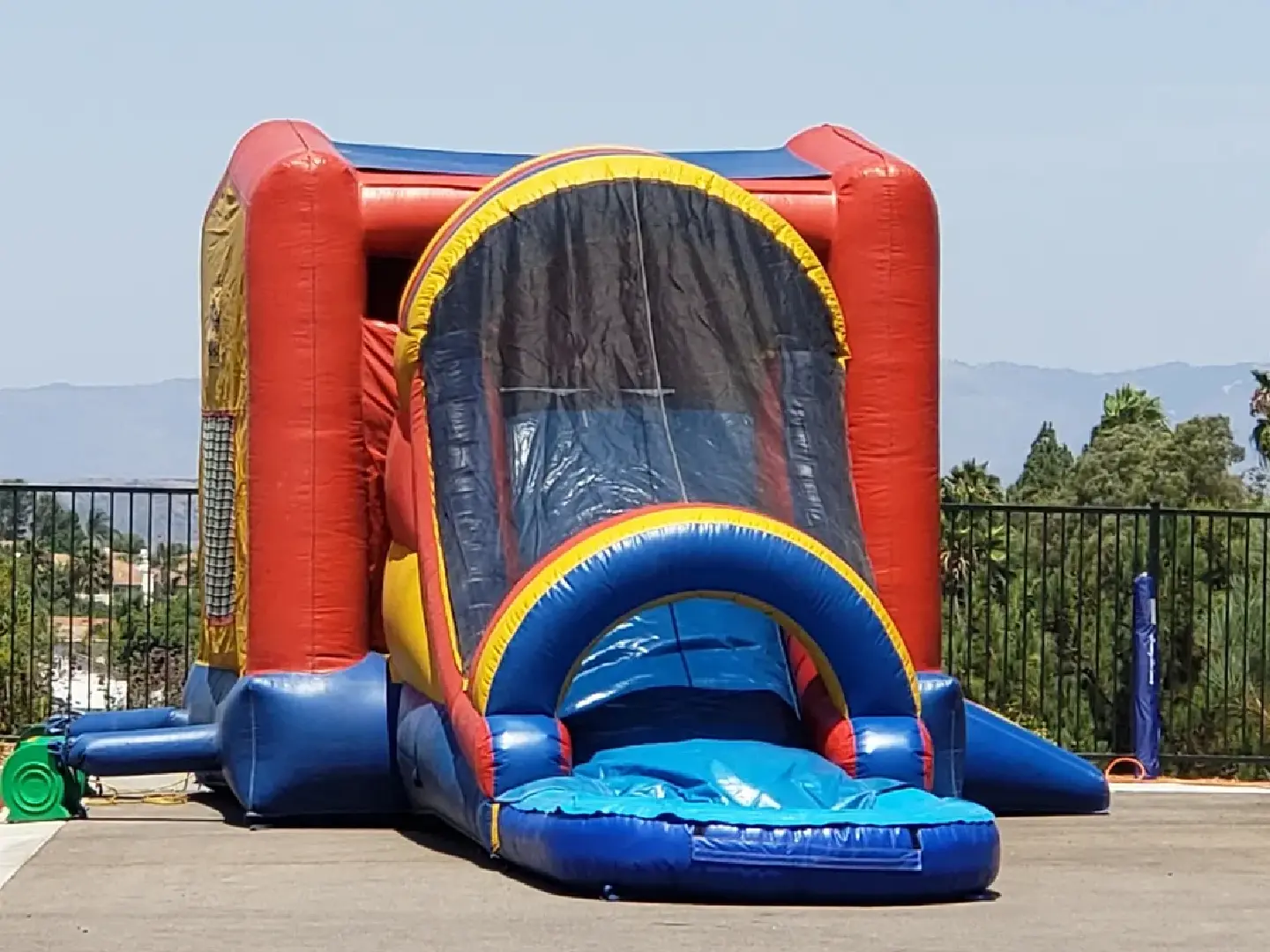 A bouncy house with water slide and obstacles.