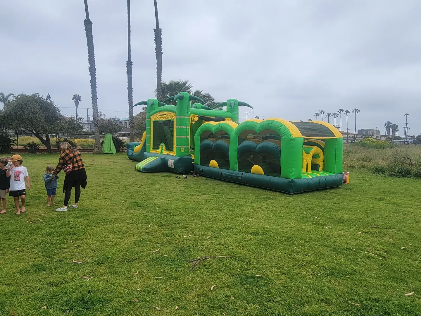 A man and woman playing in front of an inflatable obstacle course.