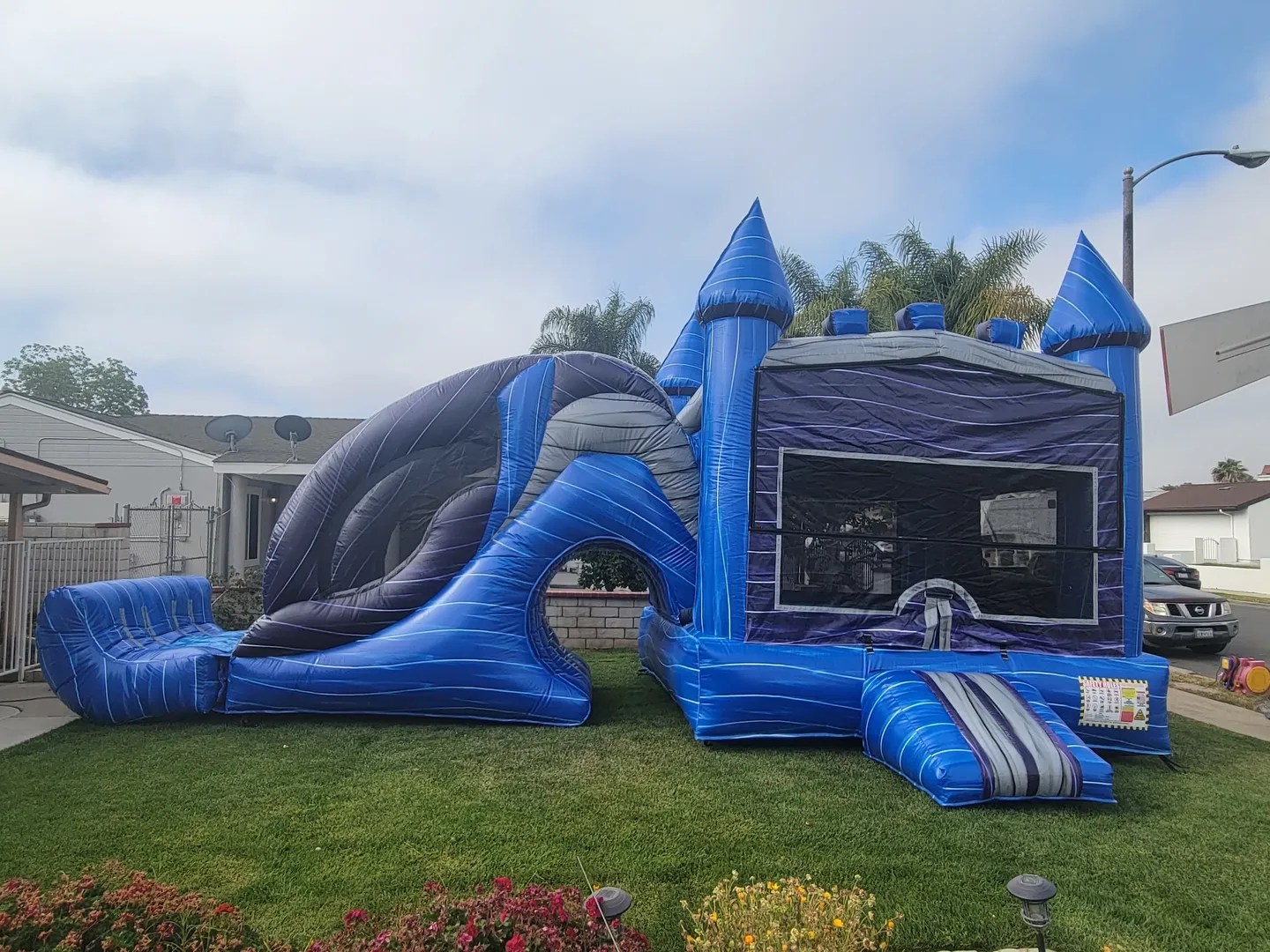 A blue and silver bouncy castle with slide.